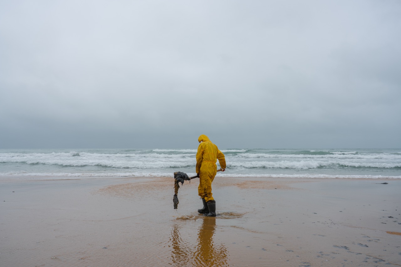 Groß (5 - Volunteer Gleb cleans up large blobs of fuel oil washed up on the shore after a .jpeg