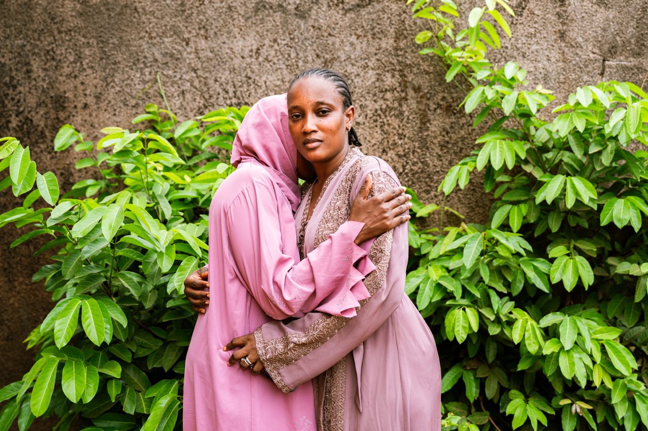 Groß (4 - Adama and Mariama Diallo hug in the courtyard of their concession in Conakry. - 