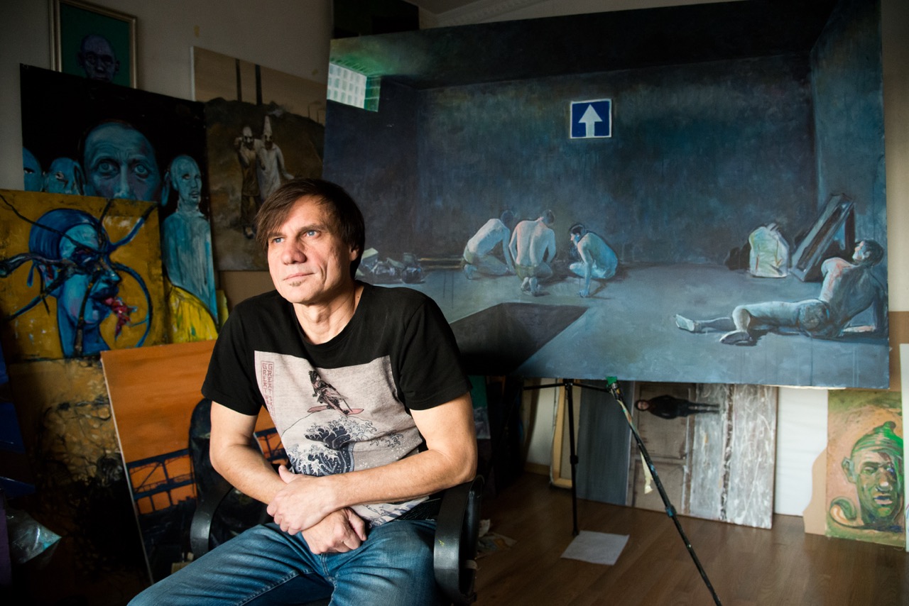 Groß (9 - Serhii Zakharov- a former resident of Donetsk- poses next to his artworks depict.jpeg